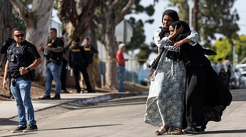 TWO women react as they leave a reunification center following the shooting at the Islamic Center of San Diego in southern California. A shooting at the largest mosque complex in San Diego killed three people, with two suspected teenage gunmen later found dead in a car from self-inflicted gunshot wounds, police said.