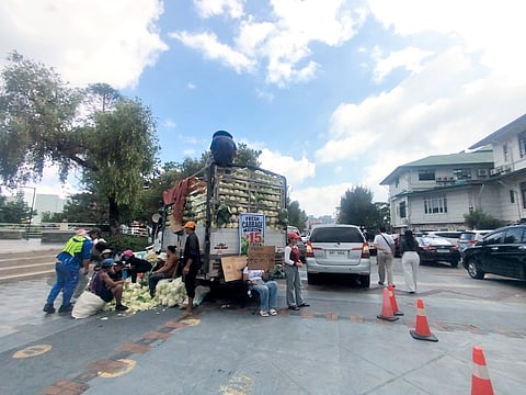 WORKERS from the local government of Baguio provide consumers fresh produce being sold at a low price inside the City Hall grounds recently.