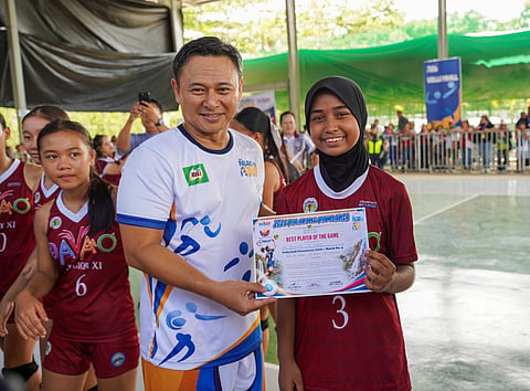 Education Secretary Sonny Angara (left) personally recognized Davao volleyball spiker Sittie Zhairah Amer as Player of the Game, celebrating her standout performance and proud representation as her team's sole Muslim athlete. Her success highlights the Palarong Pambansa’s evolving commitment to inclusion, supported by the Department of Education's (DepEd) efforts to respect and accommodate the diverse faiths of young Filipino learners.