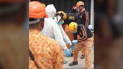SEARCH and rescue personnel wearing protective gear conduct a search and retrieval operation at the collapsed building in Angeles City, Pampanga on Wednesday.