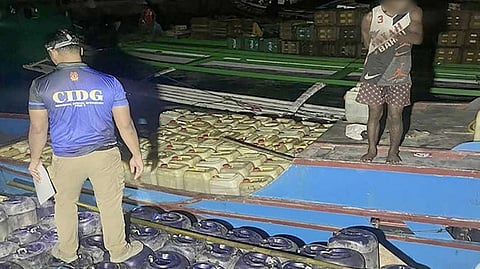 AUTHORITIES inspect some of the 700 containers of illicit gasoline seized during a joint law enforcement raid in Barangay Baliwasan. Operatives from the Criminal Investigation and Detection Group and the local police intercepted the illegal petroleum trading operation.