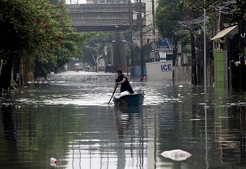 A MAN navigates a small boat through a flooded section of N.S. Amoranto Street corner Araneta Avenue in Quezon City on Saturday, 19 July, as continuous rains brought by the southwest monsoon (Habagat), intensified by severe tropical storm ‘Crising,’ inundated the area.