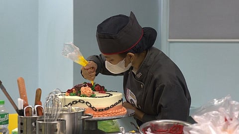 A student demonstrates cake decorating skills during the Worth the Whisk competition at STI Tagisan ng Talino.