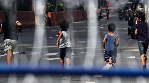 CHILDREN play along a portion of Recto Avenue in Manila amid the barricades and razor wires as the road was closed to prevent motorists from using the road.