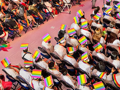 LGBTIQ+ graduates wear rainbow-colored caps and sashes as they take part in the special commencement ceremony.