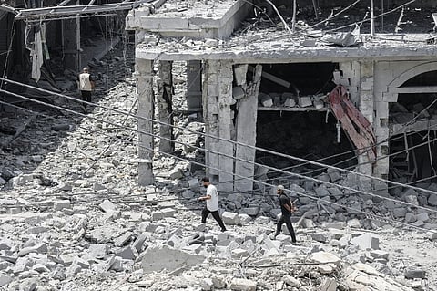 PEOPLE make their way through the heavily damaged historic market of Nabatieh as residents displaced by fighting return to southern Lebanon.