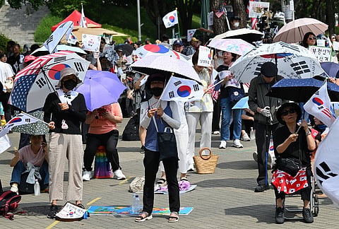 SOUTH Korean protesters hold umbrellas and wave national flags outside the SK Olympic Handball Gymnasium, which served as a vote-counting center, in Seoul on 17 June 2026, amid ongoing protests demanding a rerun of the 3 June local elections due to ballot paper shortages.