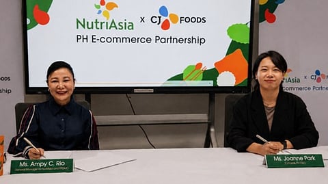 NUTRIASIA general manager Ampy Rio (left) and CJ Foods Philippines chief executive officer Joanne Park sign a memorandum of agreement formalizing the strategic e-commerce partnership between the two companies aimed at expanding Filipino consumers' access to Korean food products through major online shopping platforms.