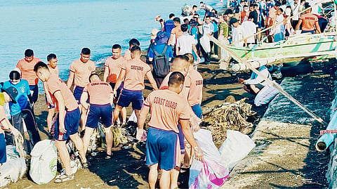 VOLUNTEERS from SM City Batangas clean the coast.