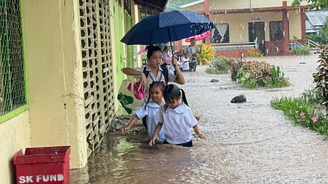 CHILDREN of Panitian Elementary School in Sofronio Española, Palawan wade through waist-deep floodwaters after a sudden downpour inundated their campus on Monday, while a teacher races to save important school documents from the rising water.
