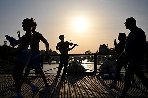 A VIOLINIST plays under the sun on the Pont des Arts footbridge during the annual Fête de la Musique street festival on 21 June 2026, as a severe heatwave grips parts of France, where multiple departments remain under red alert.