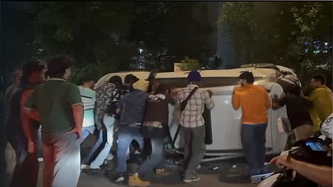 People lifting the overturned car