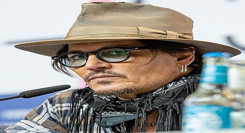 Johnny Depp looks disheveled as he's escorted out of hotel