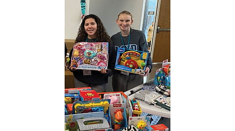 Mount Notre Dame students Alana Davis and Clair Knapmeyer display toys they helped collect during last year’s St. Vincent de Paul toy drive.
