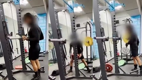 A person arguing over weights and throwing 20 kg plates onto the floor at the gym.