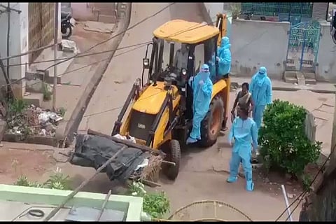 Earth mover used to transport dead body of covid patient