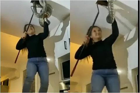 Watch the video of a young woman pulling out snakes from the ceiling of her house