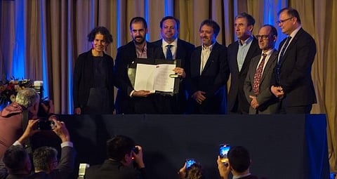 The signatories of the agreement between the Chilean government and the salmon companies whereby Cooke and AquaChile will relocate nine aquaculture concessions to protect national parks pose for photographers after signing the agreement.