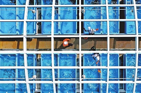 Employees work around aquaculture ponds in the China National Offshore Oil Corp (CNOOC) Guangdong Dapeng LNG terminal in Dapeng New Area in eastern Shenzhen.