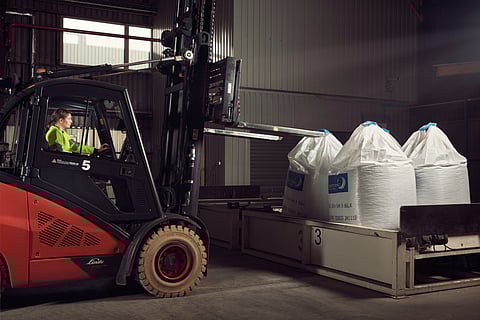 Worker handling feed sacks in a Skretting factory.