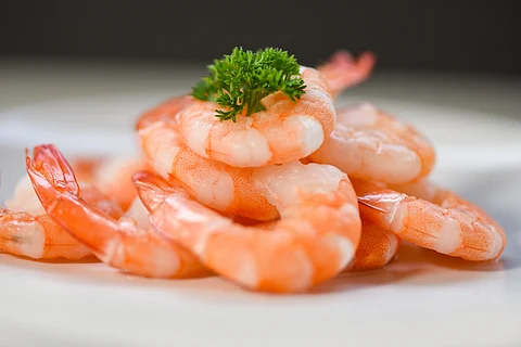 Fresh shrimps served on plate - boiled peeled shrimp prawns cooked in the seafood restaurant.