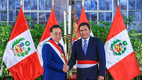Peru's new President, José María Balcázar, shakes hands with the Minister of Production, César Manuel Quispe Luján.