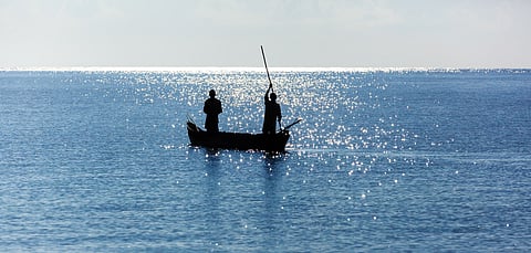 male fisherman floats on a wooden boat in the ocean, Wooden boat on the waves of the ocean, fisherman, Coast of Mombasa, Kenya, ocean, clouds, coast