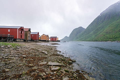 Old wooden building on the beach in the city of Mosjoen in Northern Norway during rainy weather. Architecture, landscape near me and travelocity concept.
