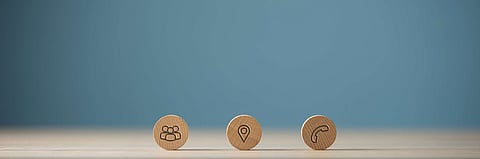 Wide view image of three wooden cut circles with contact and information icons on them placed in a row. Over blue background with copy space.