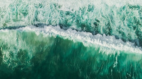 Aerial wave background. Drone shot directly from above, green turquoise color, huge waves. Empty space