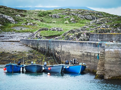Fishing boats on Ireland's coast. Photo by: Adobe Stock.