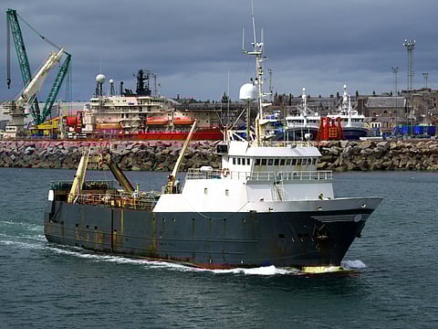 Fishing trawler leaving Peterhead Harbour in Scotland. Photo: Adobe Stock.