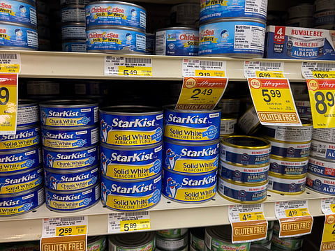 Close up view of canned seafood products for sale inside a grocery store. Photo by: Adobe Stock.