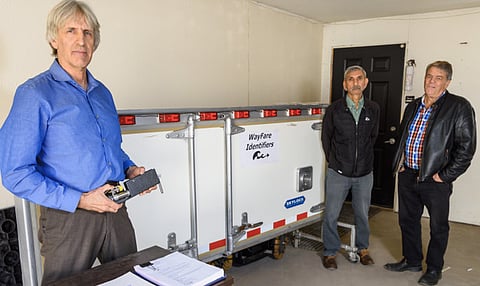 David Elderfield, CEO of WayFare Identifiers Inc., left, Dave Sangra, a contractor with the company, and Roger Sparks, head of marketing, pose for a photo with company documents and a prototype of a containerized cargo security system. The Canada Revenue Agency destroyed the company that would have protected shipping containers from being used for terrorism or human trafficking purposes.