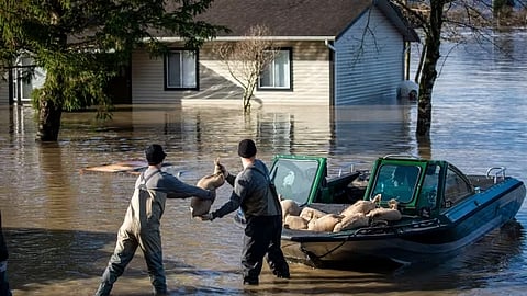 Volunteers load sandbags into a boat for transport to farms in the Sumas Prairie flood zone in Yarrow, BC, on Nov. 19, 2021.