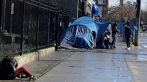 Pandora Street, Victoria B.C., March 15, 2025, a daily scene with tents set up near the major shelter and food service. A series of transactions like this one can be seen. Victoria officials have conducted multiple sweeps on the street, and millions are spent to displace and clean up encampments in city parks.