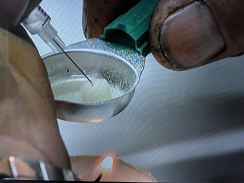An addict prepares a drug injection at the Sheldon Chumir Safe Consumption Site in Calgary