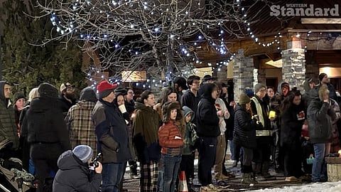 Tumbler Ridge residents holding candles at a vigil for victims of Tuesday's shooting.