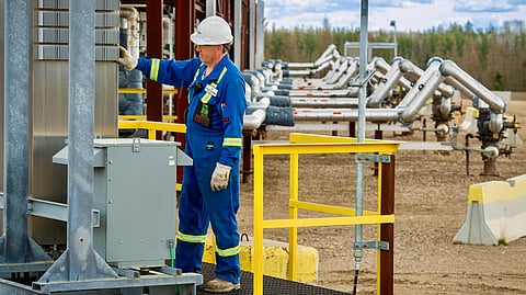 An oilfield worker monitors a facility