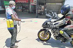 A worker disinfects one of the participant’s bike at MMRT in Irungattukottai, Chennai, on Sunday. According to MMRT official, a total of 24 bikers were present during the session