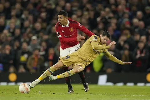 Barcelona's Robert Lewandowski, foreground, is challenged by Manchester United's Casemiro during the Europa League playoff second leg soccer match at Old Trafford stadium, Feb. 23, 2023. (Photo | AP)