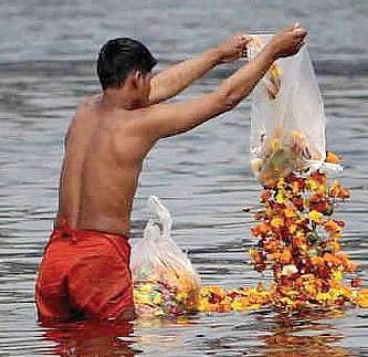A man dumps waste in the Ganga