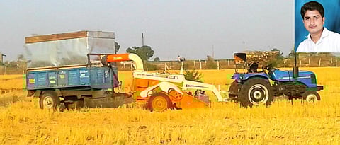 Straw reaper attached to the tractor and trolley to collect the straw attached to it
