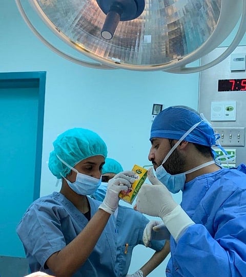 Dr. Abdul Razaq Al-Huzaimi was seen in the image as helped by a nursing assistant to drink juice to break his fast while performing surgery. 