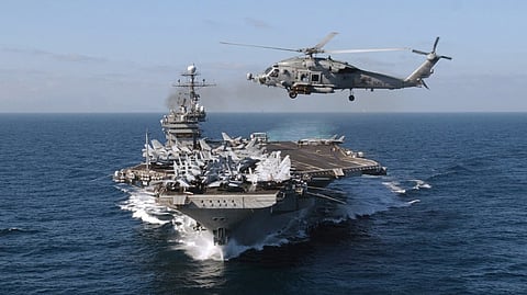 An HH-60H Seahawk helicopter assigned to the "Nightdippers" of Helicopter Anti-Submarine Squadron Five (HS-5) crosses the bow of the aircraft carrier USS John F. Kennedy as the carrier Battle Group (BG) arrived in the Mediterranean Sea, February 23, 2002.