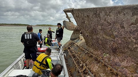 Rescue divers from the Brownsville Fire Department inspect the overturned shrimp trawler in the waters of the Brownsville ship channel, July 13, 2025.