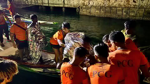 Philippine Coast Guard personnel assisting the rescued passengers and crew of a jungkung-type wooden boat that had capsized off Sulu province in the southern Philippines, August 5, 2025