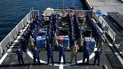 The crew of the US Coast Guard cutter USCGC Escanaba stand at parade rest near the seized contraband on the cutter's flight deck at Port Everglades, Florida, August 5, 2025. The contraband was later transferred to partner agencies for accountability and destruction.