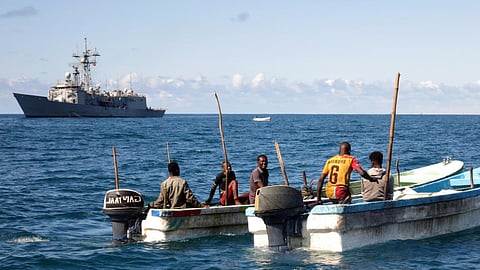 Somali boats gather near the coast as the Spanish Navy frigate Reina Sofia conducts a counter-piracy patrol off in the distance sometime in November 2020.