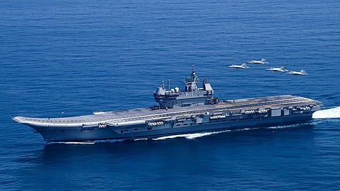 The Indian Navy aircraft carrier INS Vikrant steams off the west coast of India with a formation of four MiG-29K fighter aircraft flying overhead during Exercise Konkan 2025.